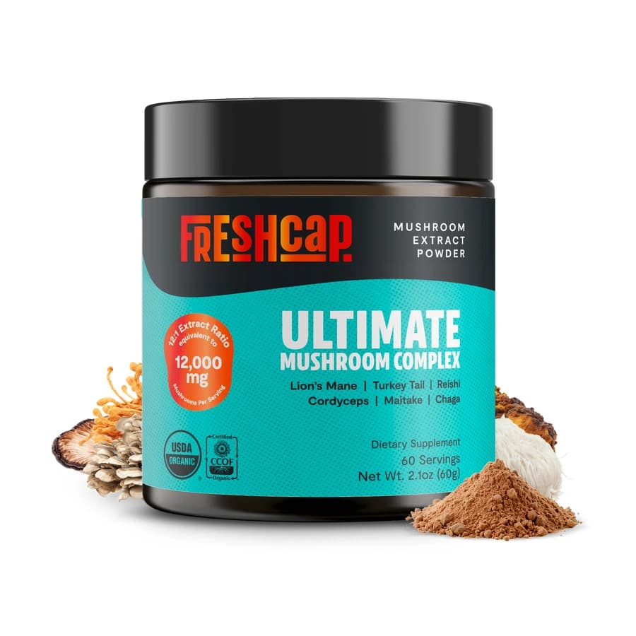 FreshCap Ultimate Mushroom Complex powder jar with a turquoise label and mushrooms beside it.